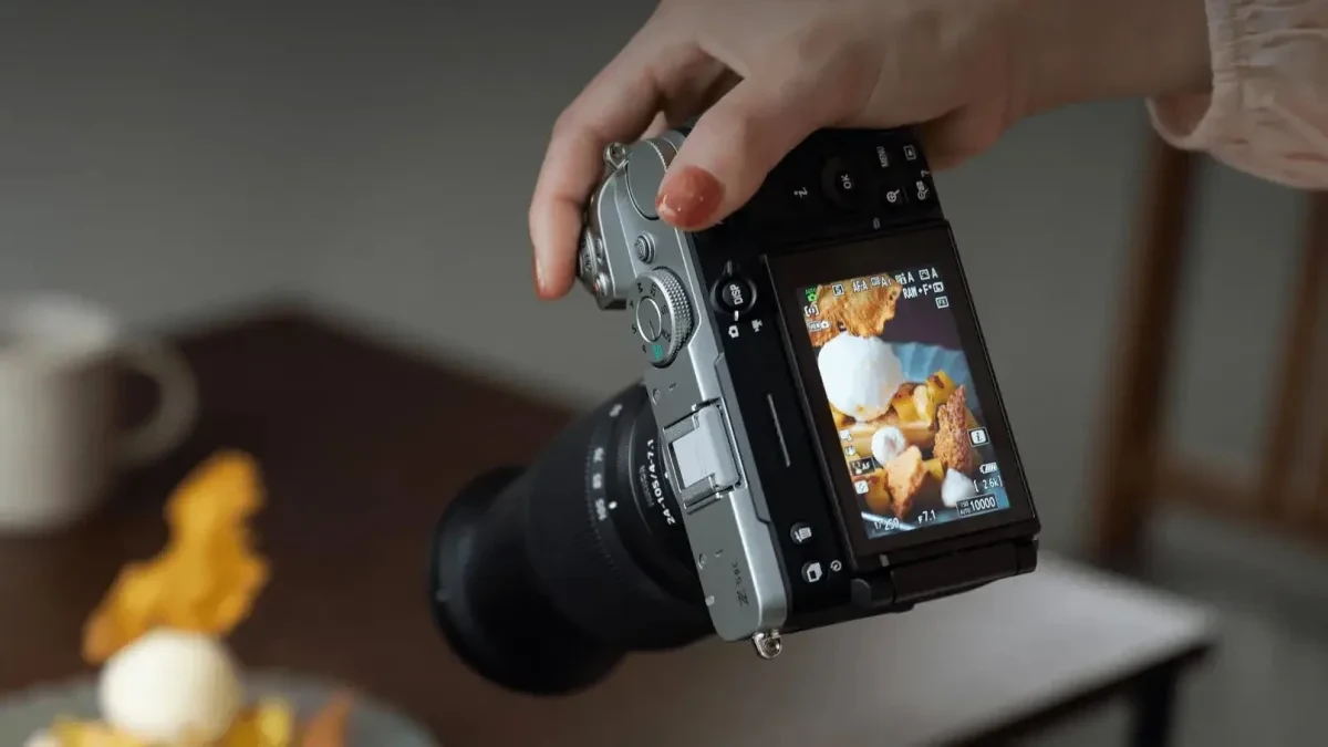 Kamera mirrorless Nikon Z5IIC berwarna hitam dengan lensa terpasang